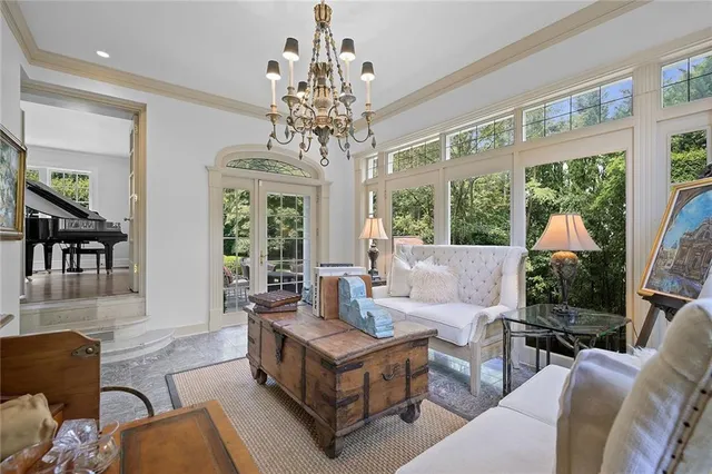 a living room with furniture chandelier and a large window