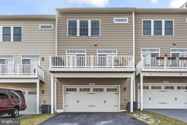 a front view of a house with a garage and balcony