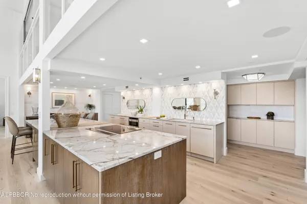 a large kitchen with kitchen island a sink table and chairs