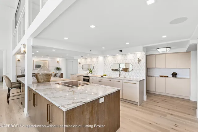 a large kitchen with kitchen island a sink table and chairs