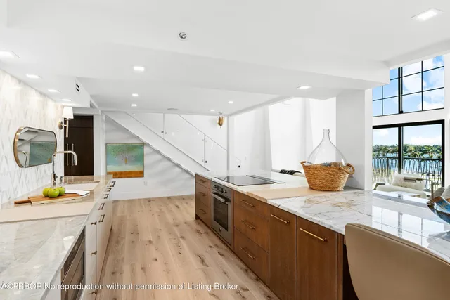 a kitchen with stainless steel appliances granite countertop a sink a stove and a refrigerator