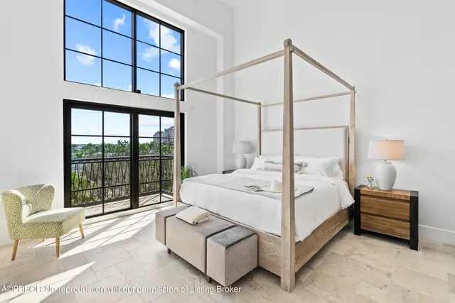 a bedroom with a bed lamp and large window