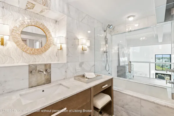 a spacious bathroom with a granite countertop sink mirror and bathtub
