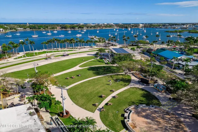 an aerial view of a city with lots of residential buildings ocean and mountain view in back