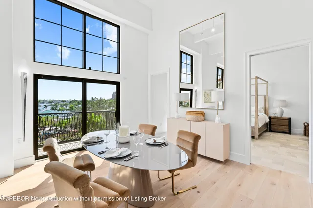 a dining room with furniture a large window and a chandelier