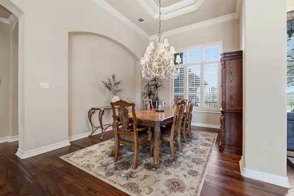 a view of a dining room with furniture a chandelier and wooden floor