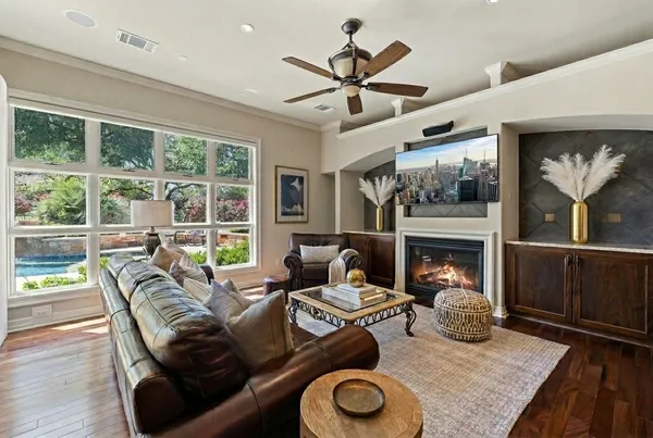 a living room with furniture a flat screen tv and a large window