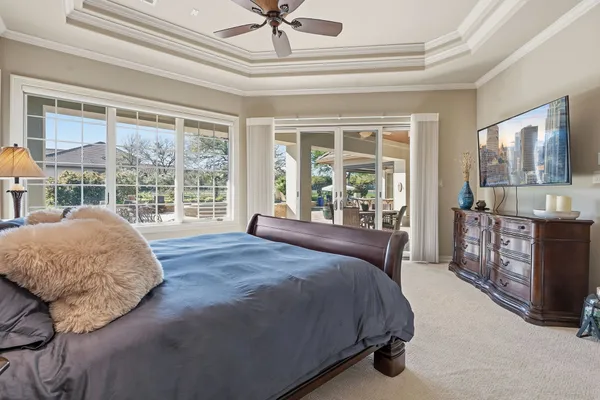 a bedroom with a bed and large windows