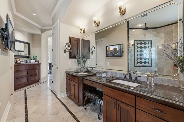a bathroom with double vanity sinks a mirror and a shower