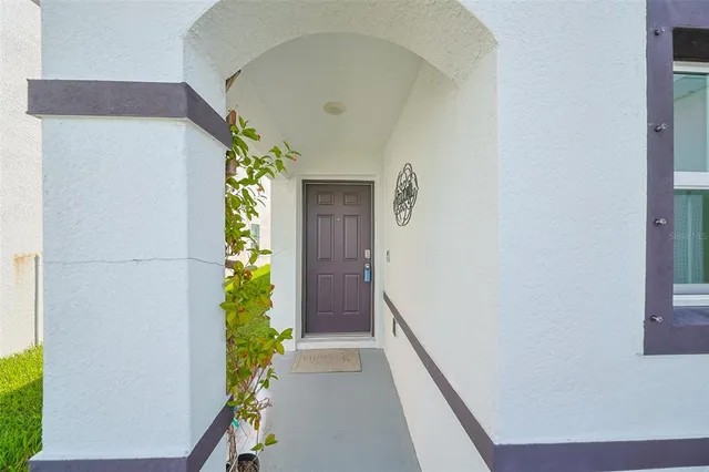 a hallway with wooden floor and a potted plant