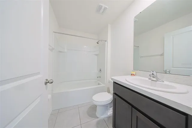 a bathroom with a granite countertop sink a toilet and shower