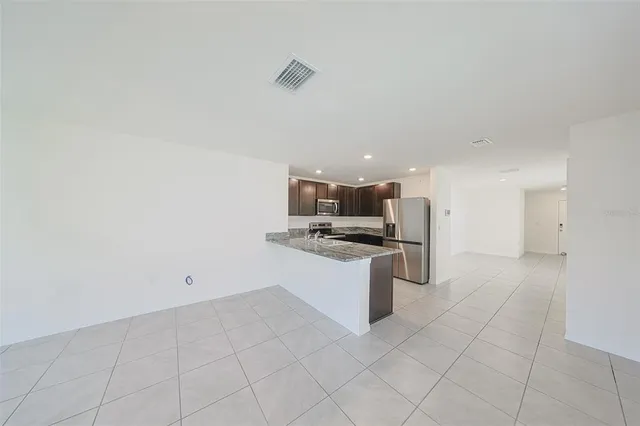 a kitchen with granite countertop a sink and white cabinets