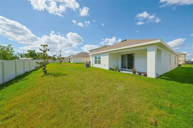 a yellow house with flower garden in front of it