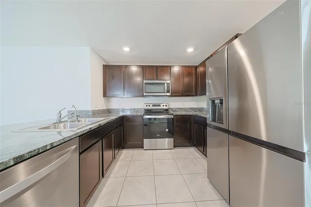 a kitchen with stainless steel appliances granite countertop a sink counter space and cabinets