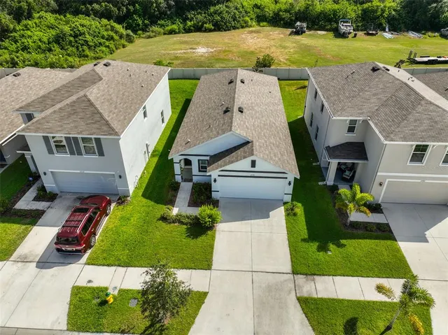an aerial view of a house with a yard basket ball court and outdoor seating