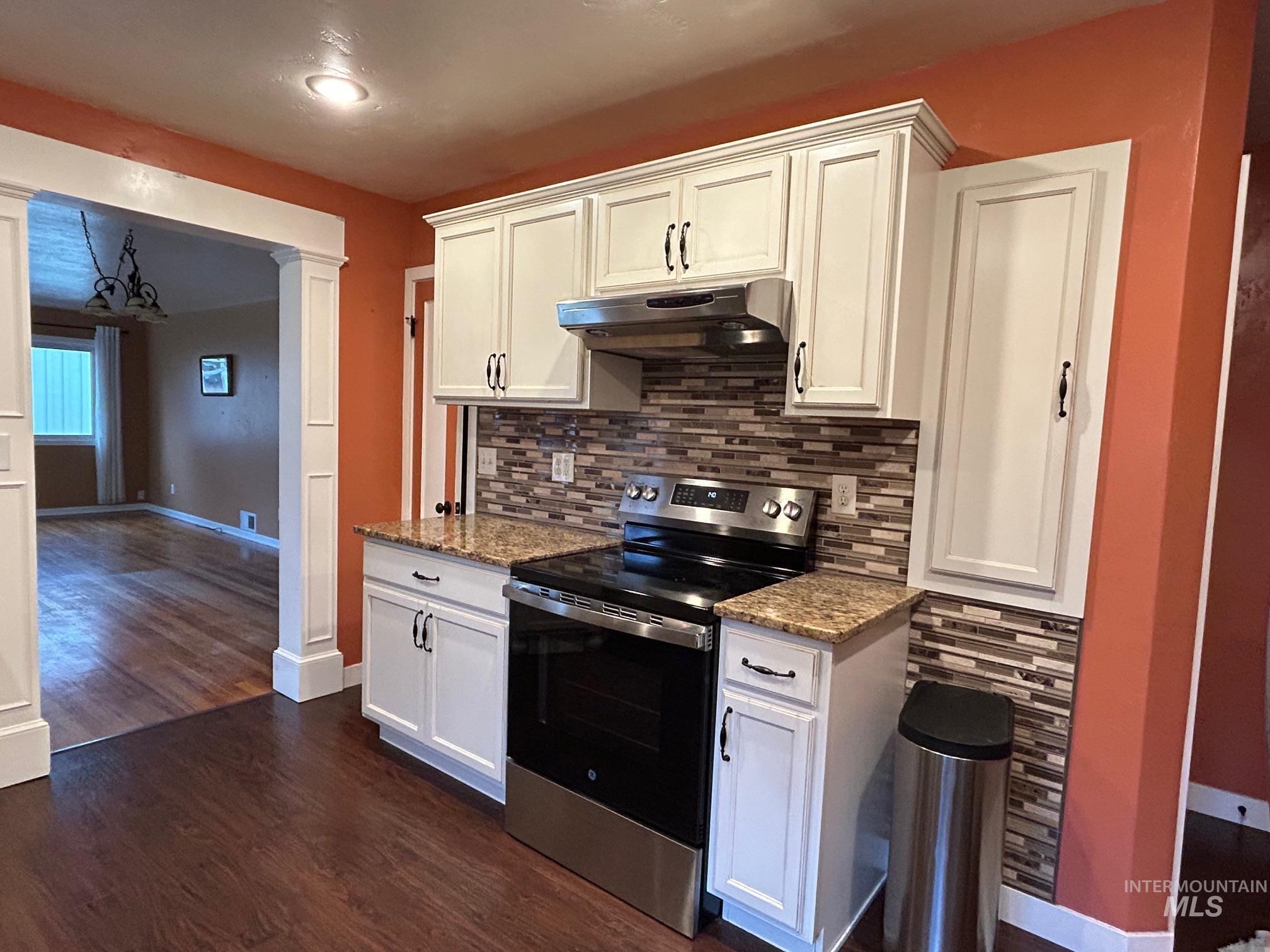 112 17th Avenue Lewiston, ID 83501 - Photo 12 of 40 Kitchen with stainless steel range with electric stovetop, white cabinetry, dark stone counters, decorative columns, and backsplash