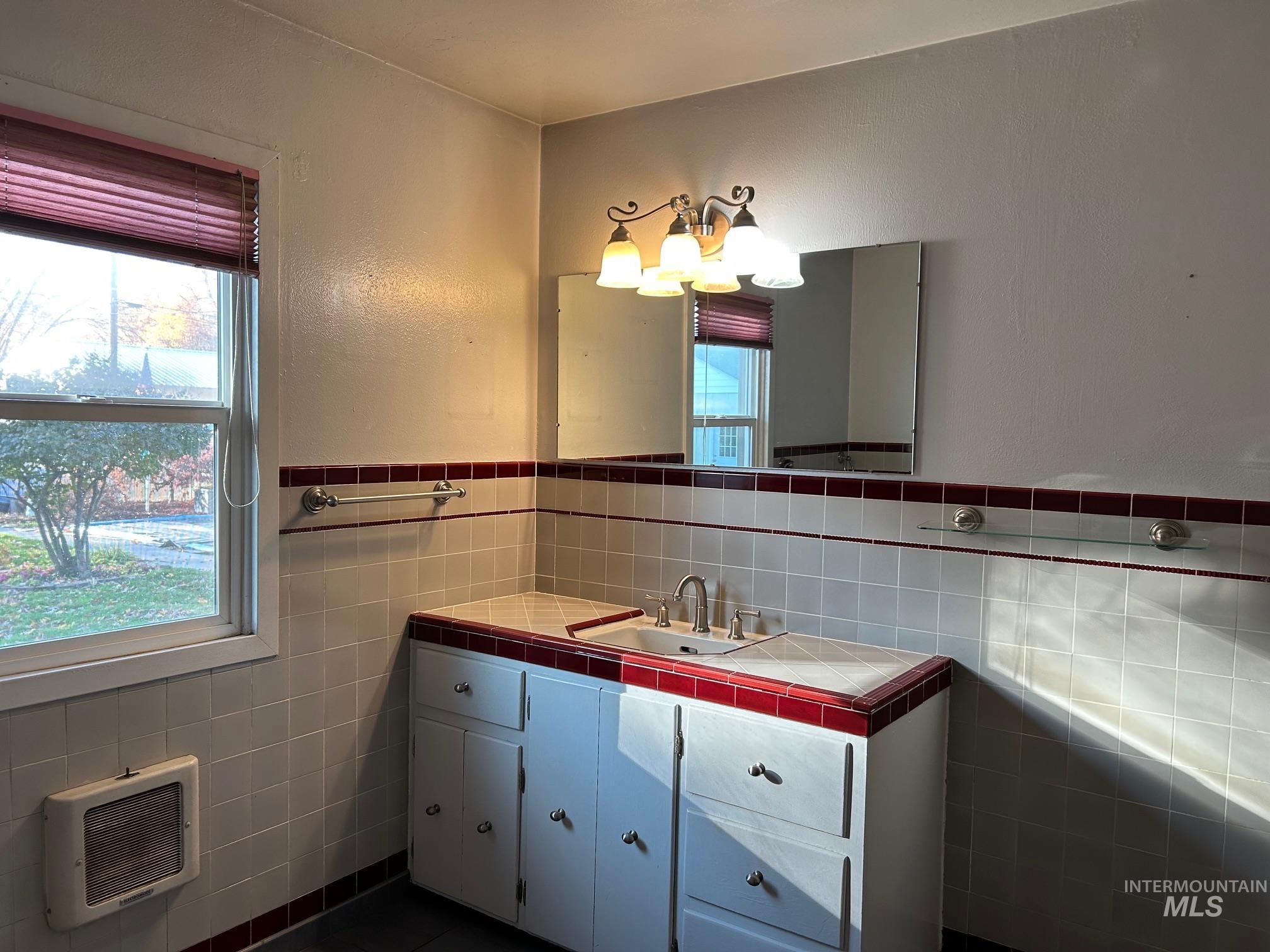112 17th Avenue Lewiston, ID 83501 - Photo 24 of 40 Bathroom featuring tile walls, vanity, heating unit, and wainscoting