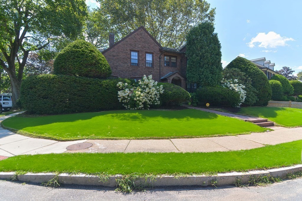280 Common Street Belmont, MA 02478 - Photo 2 of 36 a view of a brick house with a yard and potted plants and large trees