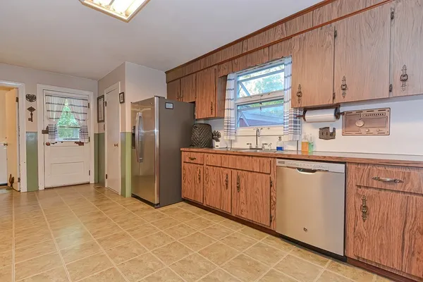 a kitchen with stainless steel appliances granite countertop a sink and a refrigerator