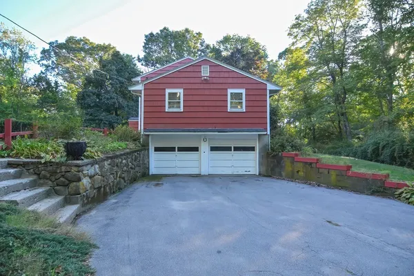a view of a yard in front of a house with large trees