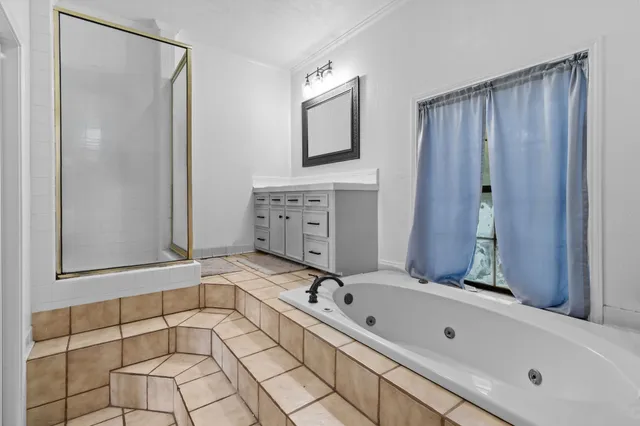 a bathroom with a tub sink and mirror