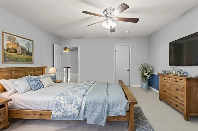 a bedroom with a large bed and a flat tv screen on dresser