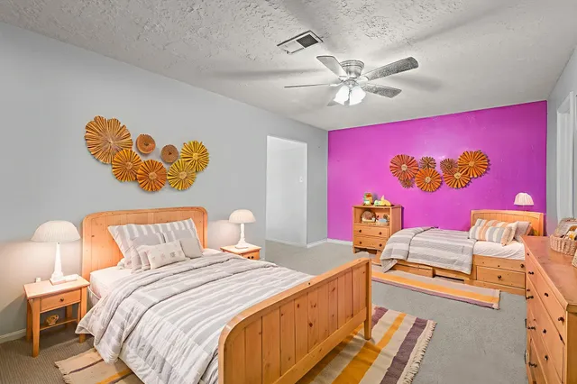 a bedroom with a bed and a painting on the wall