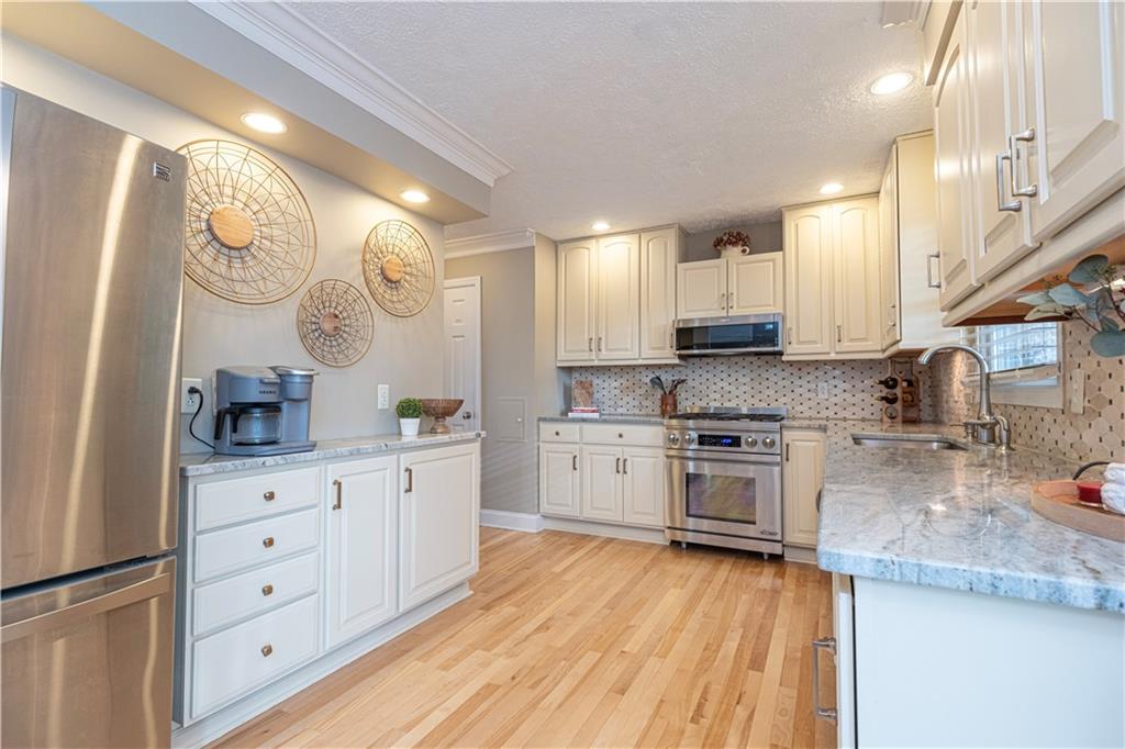 602 Hemlock Road Coraopolis, PA 15108 - Photo 8 of 40 a kitchen with granite countertop a sink cabinets stainless steel appliances and a counter top space