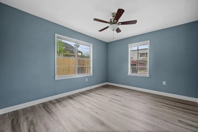 a view of a big room with wooden floor and windows