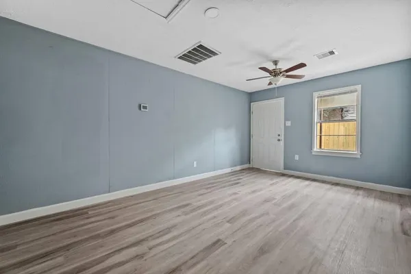 wooden floor in an empty room with a window