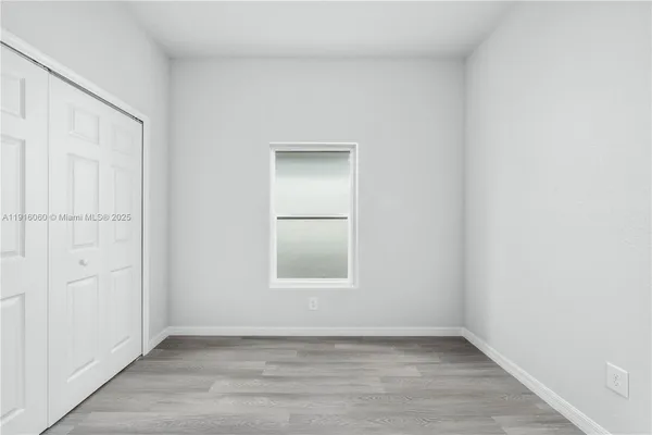 an empty room with wooden floor and closet