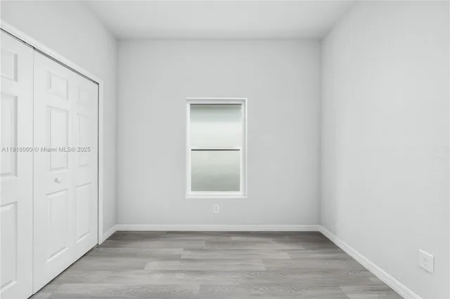 an empty room with wooden floor and closet