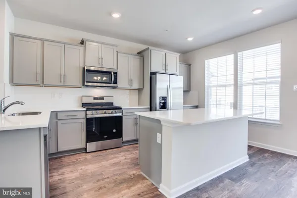a kitchen with stainless steel appliances a refrigerator sink and stove