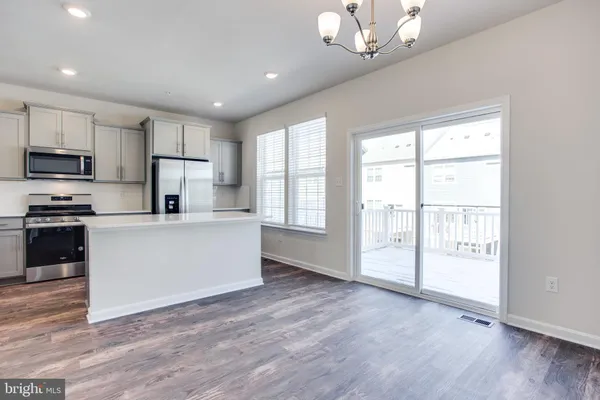 a large kitchen with cabinets wooden floor and stainless steel appliances