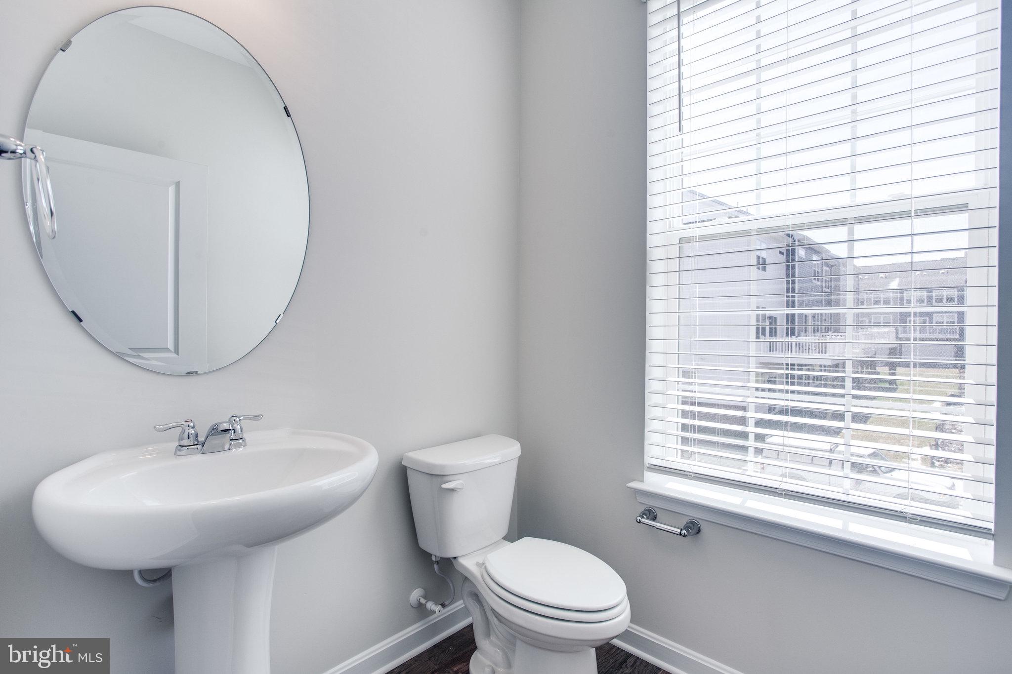 5039 MacDonough Place Frederick, MD 21703 - Photo 19 of 35 a bathroom with a toilet a sink and a mirror