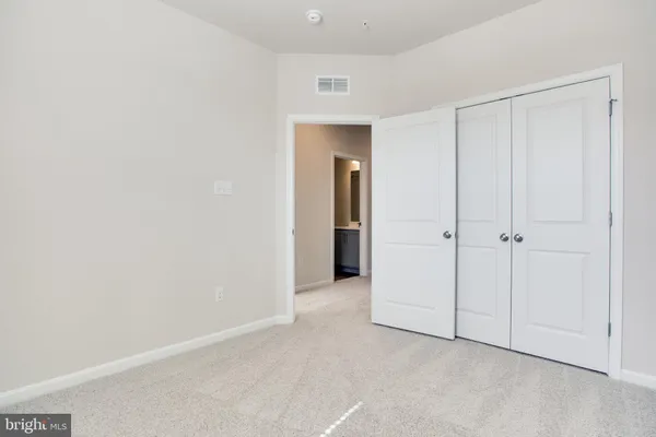 a view of an empty room and closet area