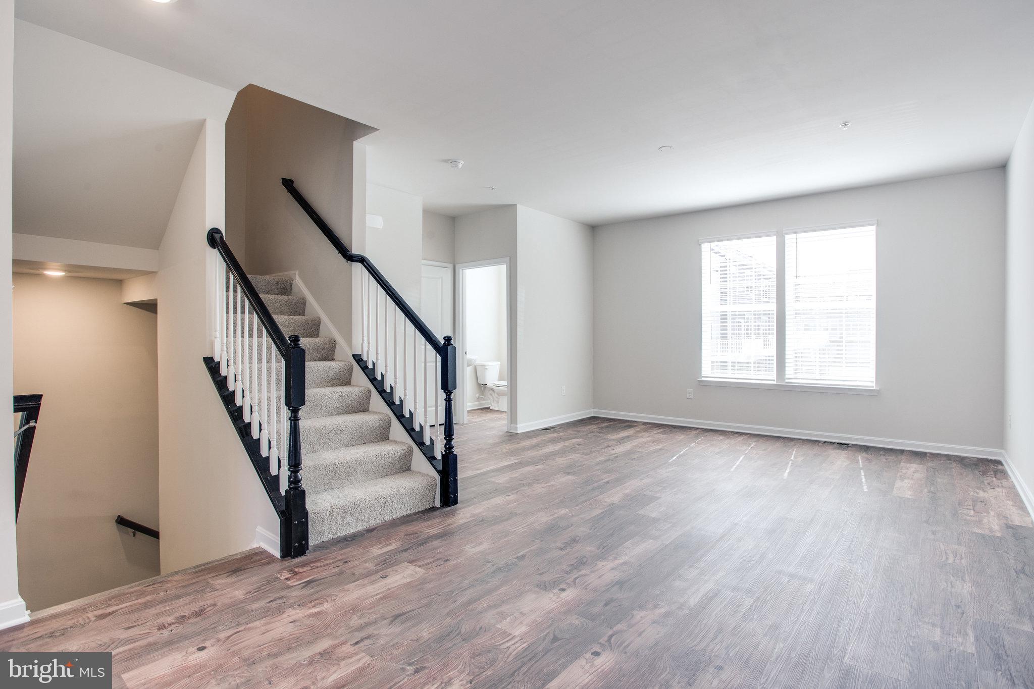 5039 MacDonough Place Frederick, MD 21703 - Photo 5 of 35 a view of an empty room with wooden floor and stairs