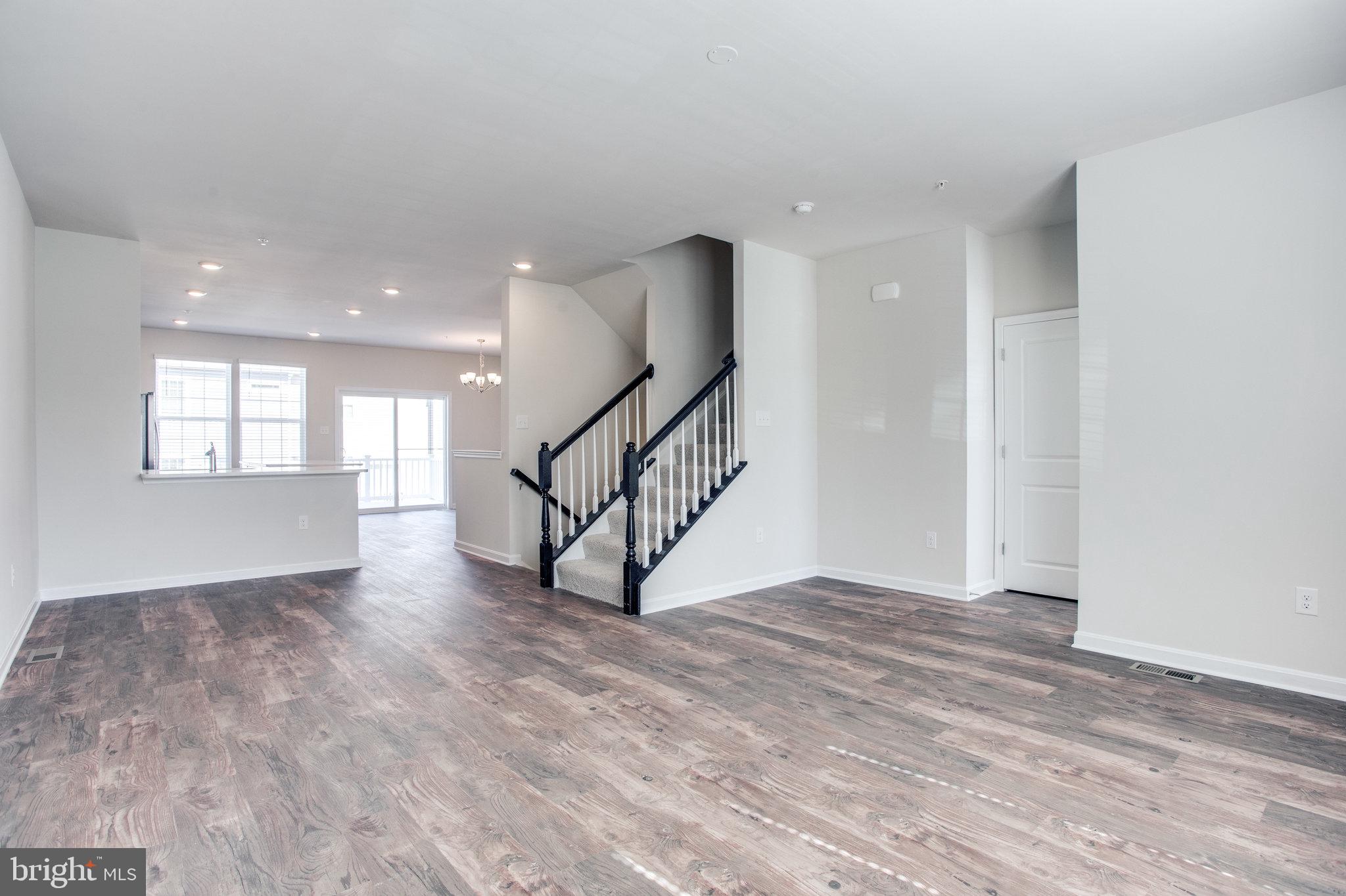 5039 MacDonough Place Frederick, MD 21703 - Photo 8 of 35 a view of an empty room with wooden floor and stairs