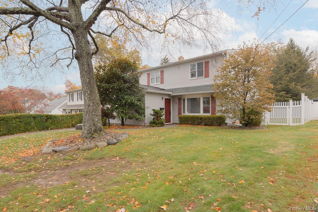 a view of a yard in front of a house with a large tree