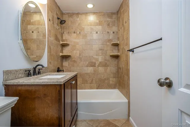 a bathroom with a granite countertop sink a mirror and shower