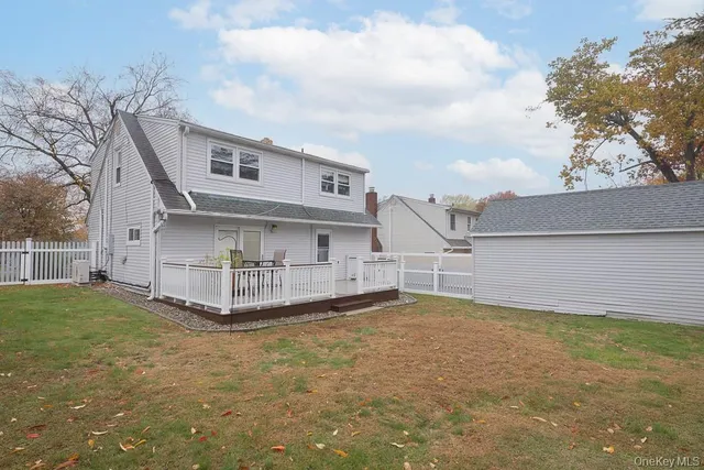 a view of a house with a big yard and large tree