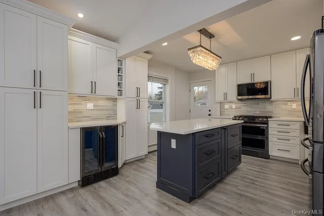 a kitchen with stainless steel appliances granite countertop a stove refrigerator and a sink