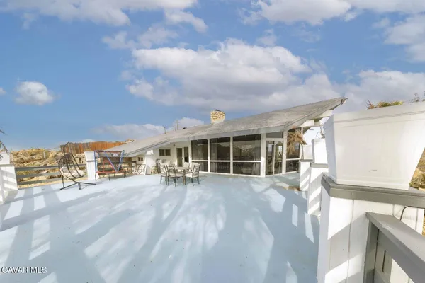 a view of a house with a large window and potted plants