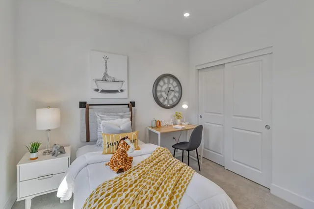 a bedroom with a bed a clock on the wall and table