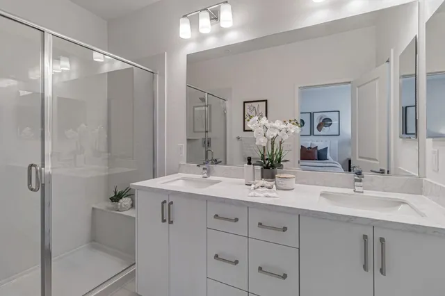a bathroom with a double vanity sink mirror double and shower
