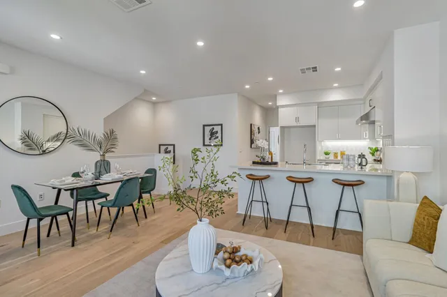 a living room with furniture a rug kitchen view and a dining table