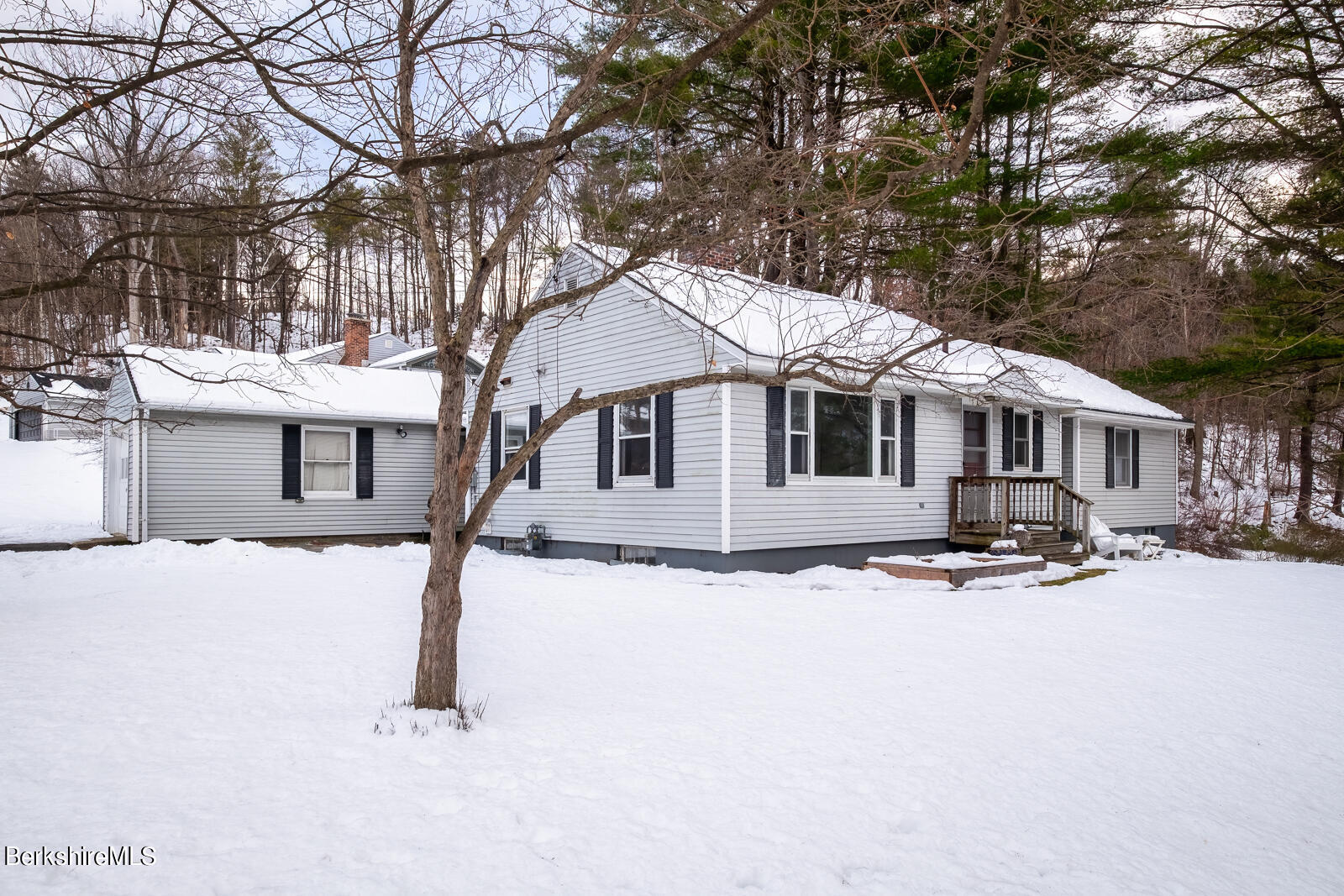 a front view of a house with a yard covered in snow