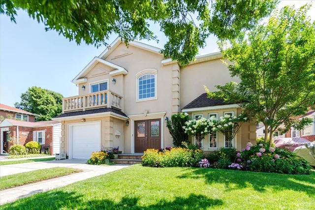 a front view of a house with a yard and green space