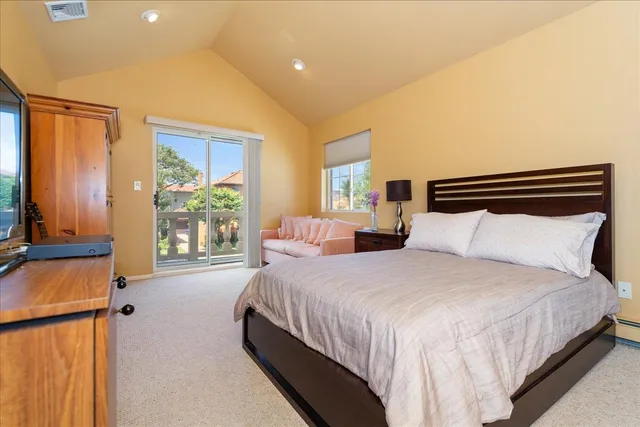 a bedroom with a bed and a dresser next to a window