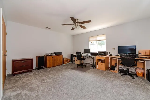 a view of a workspace with furniture and a window